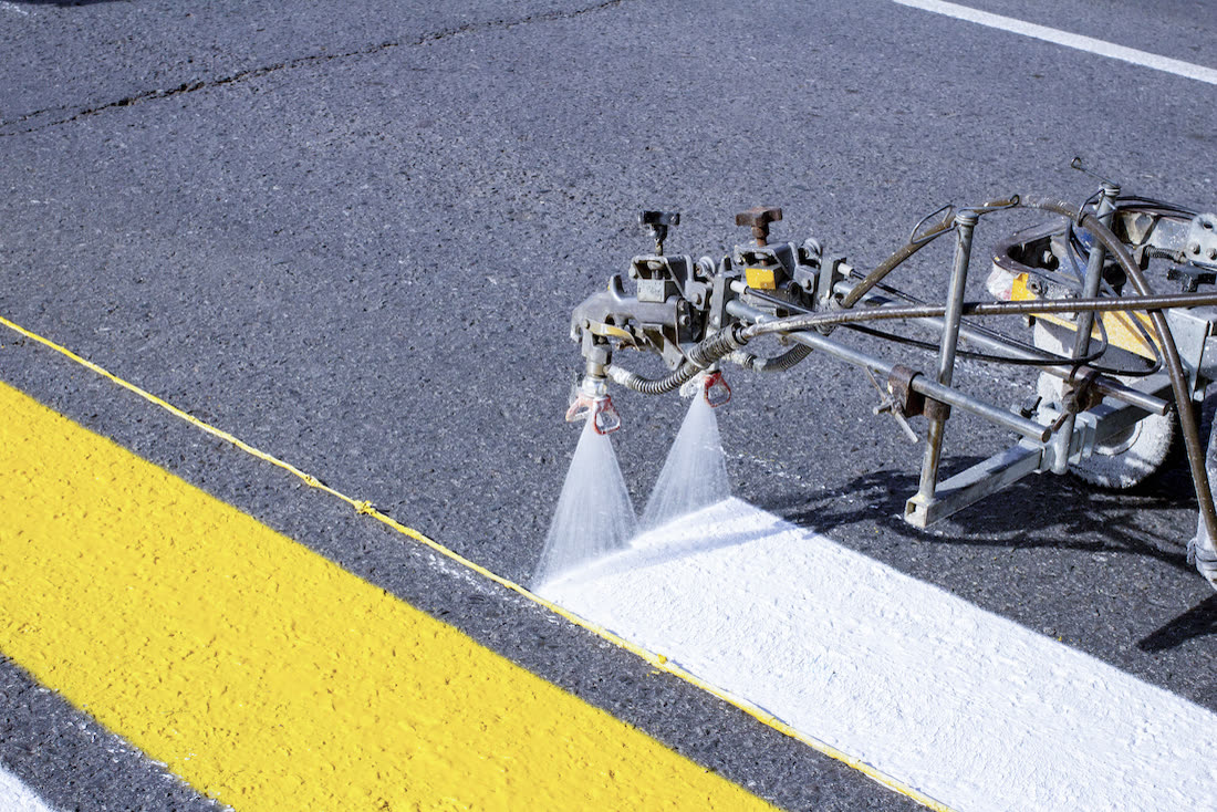 Line striping machine spraying fresh white line